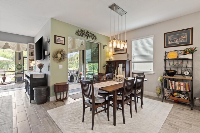11655 Renaissance Blvd, Venice, FL 34293 - dining space featuring wood tiled floor, a notable chandelier, and baseboards