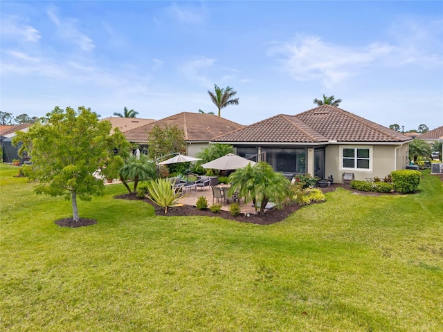 11655 Renaissance Blvd, Venice, FL 34293 - back of house featuring a tiled roof, stucco siding, a yard, and a patio