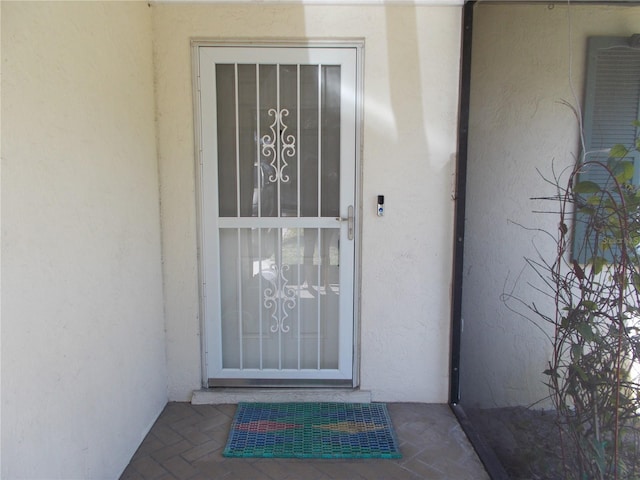 view of exterior entry featuring stucco siding