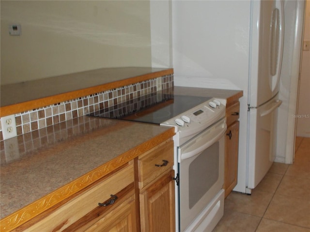 kitchen featuring light tile patterned floors, tasteful backsplash, and electric stove