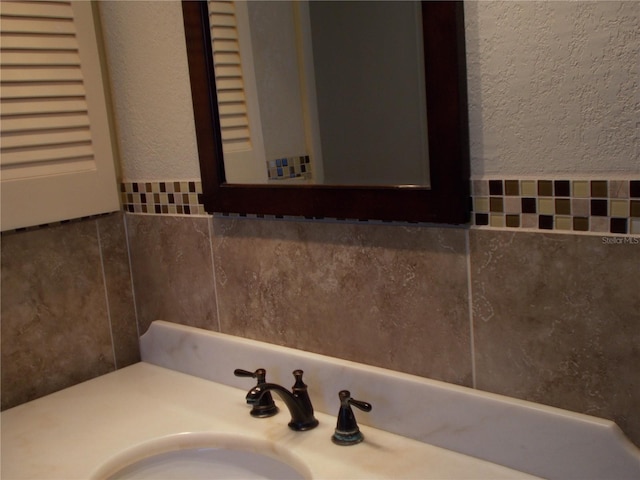 bathroom with a textured wall and a sink