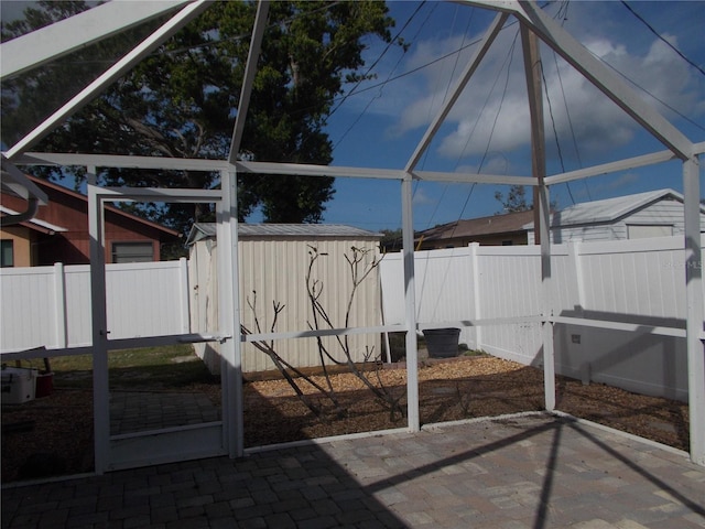 view of patio featuring an outbuilding, a fenced backyard, and a shed