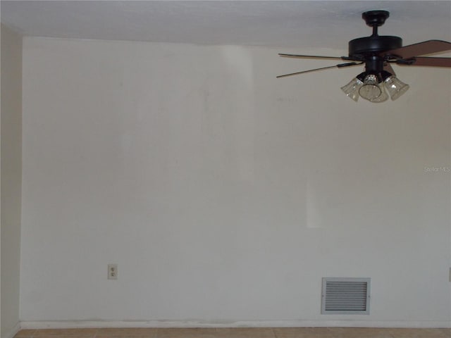 spare room with baseboards, visible vents, and ceiling fan