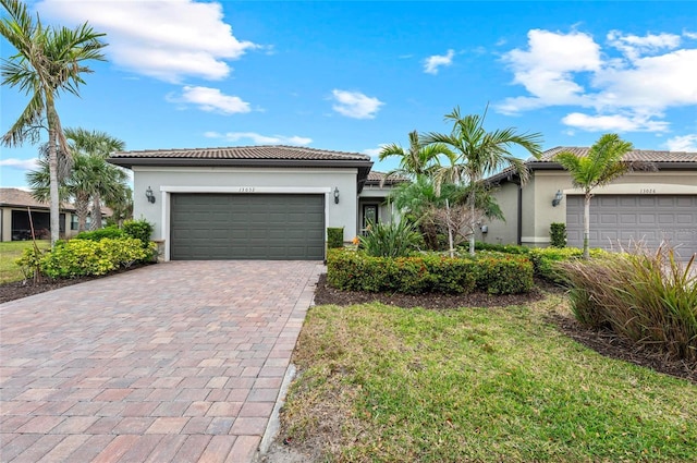 ranch-style house with a tiled roof, stucco siding, decorative driveway, and a garage