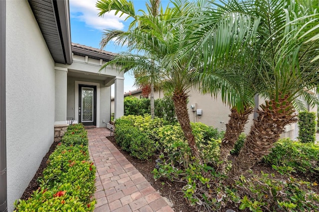 exterior space with a tile roof and stucco siding