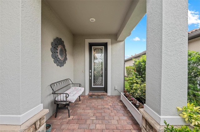 entrance to property featuring stucco siding