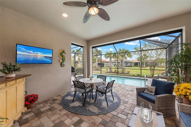view of patio / terrace featuring an outdoor pool, glass enclosure, outdoor lounge area, and ceiling fan