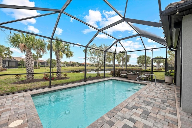 pool featuring glass enclosure, a patio area, and a yard