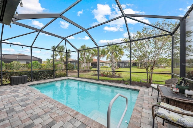 pool with glass enclosure, a lawn, and a patio