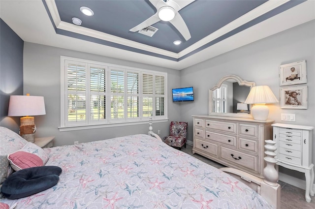 bedroom with visible vents, ceiling fan, ornamental molding, and a raised ceiling