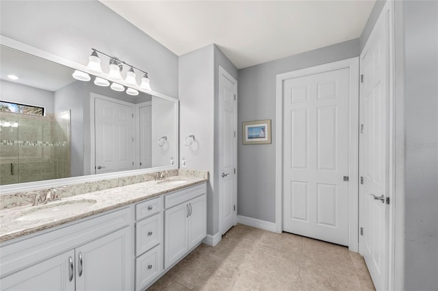 bathroom featuring double vanity, a sink, baseboards, and tiled shower