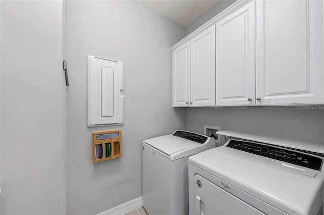 laundry room featuring electric panel, independent washer and dryer, cabinet space, and baseboards