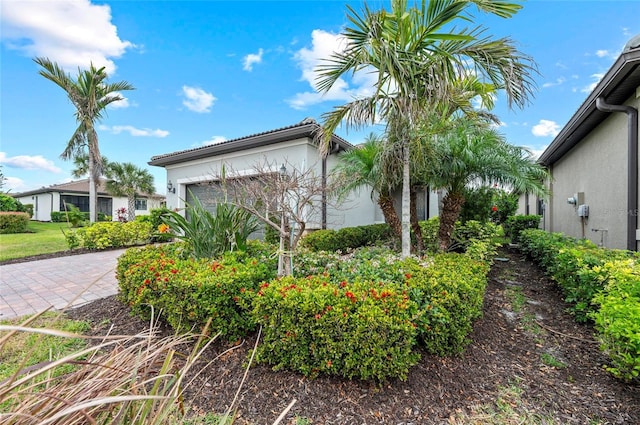view of side of property featuring stucco siding, driveway, and a garage