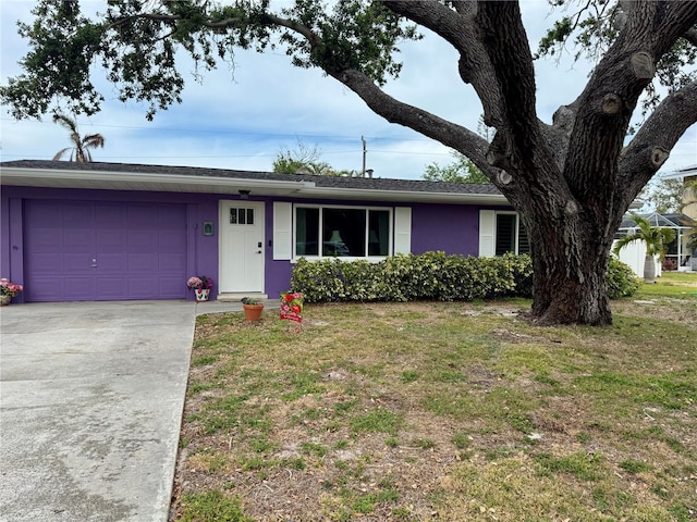 ranch-style house featuring a front yard, a garage, and concrete driveway