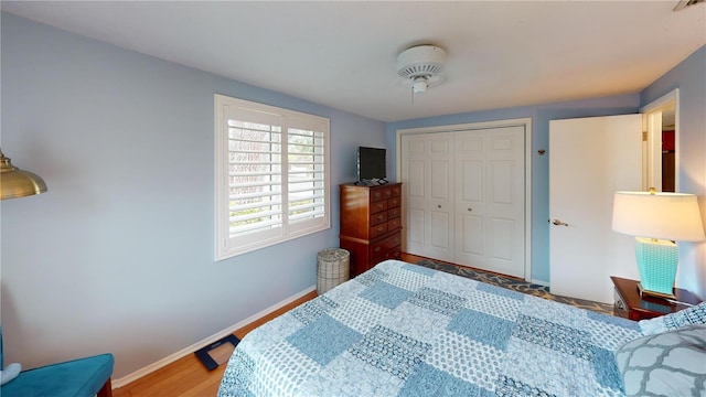 bedroom with baseboards, a closet, and wood finished floors
