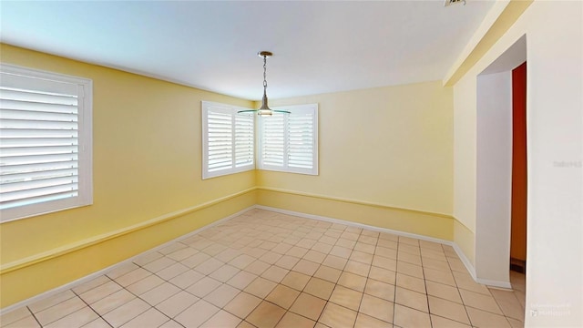 unfurnished room with baseboards and light tile patterned floors