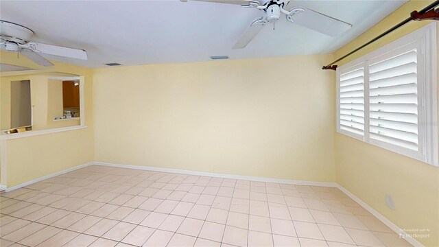 spare room with baseboards, visible vents, and ceiling fan