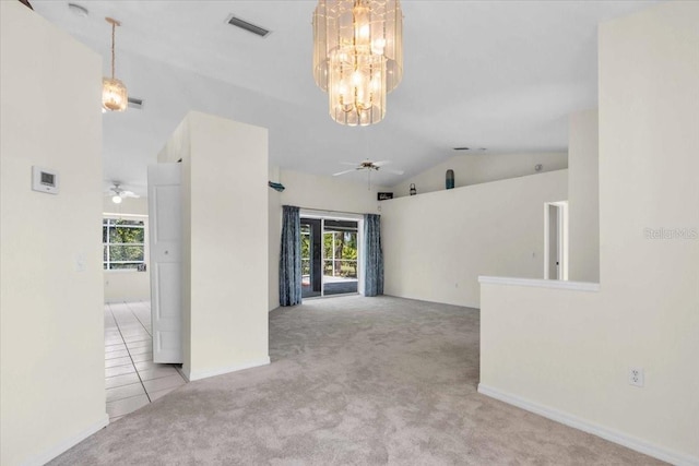 empty room featuring visible vents, carpet flooring, lofted ceiling, and ceiling fan with notable chandelier