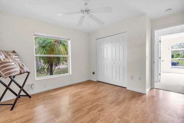 unfurnished bedroom featuring a closet, baseboards, light wood finished floors, and a ceiling fan