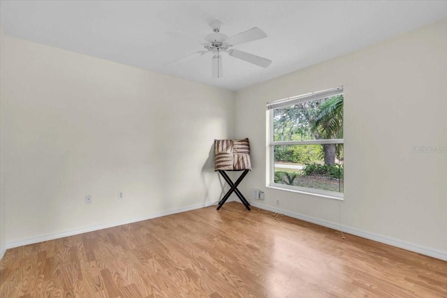 unfurnished room with baseboards, ceiling fan, and light wood-style floors