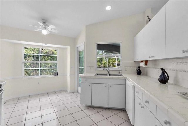 kitchen with a sink, white cabinets, plenty of natural light, and white dishwasher