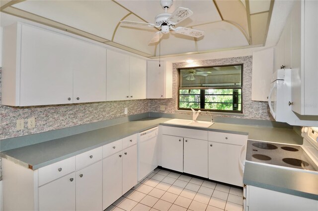 kitchen with decorative backsplash, white cabinets, white appliances, ceiling fan, and a sink