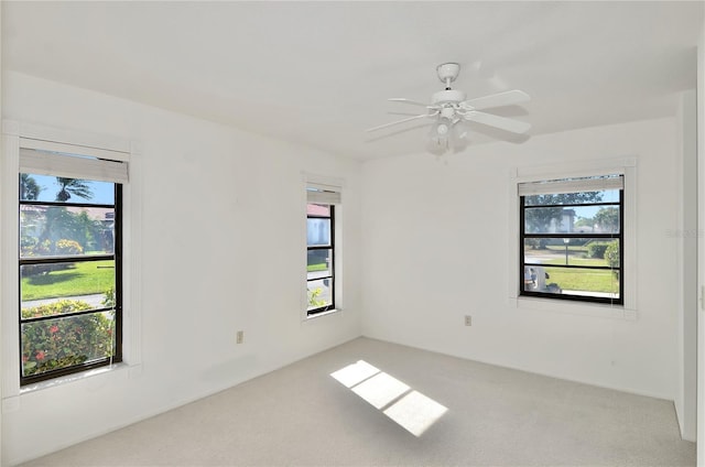 empty room featuring carpet flooring, a wealth of natural light, and ceiling fan