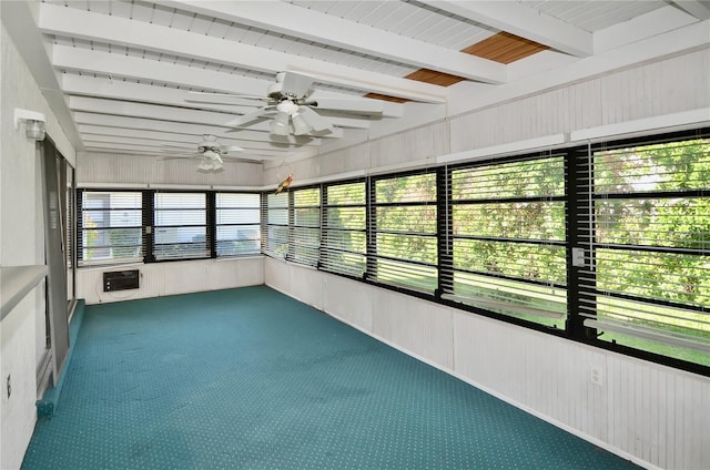 unfurnished sunroom featuring beam ceiling, a ceiling fan, and plenty of natural light
