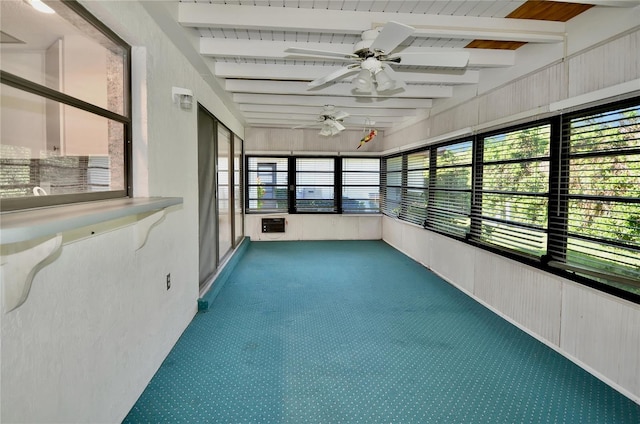 unfurnished sunroom with carpet floors, beam ceiling, and a ceiling fan