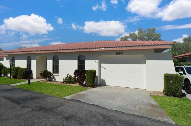 mediterranean / spanish-style home with a tile roof, driveway, stucco siding, and an attached garage