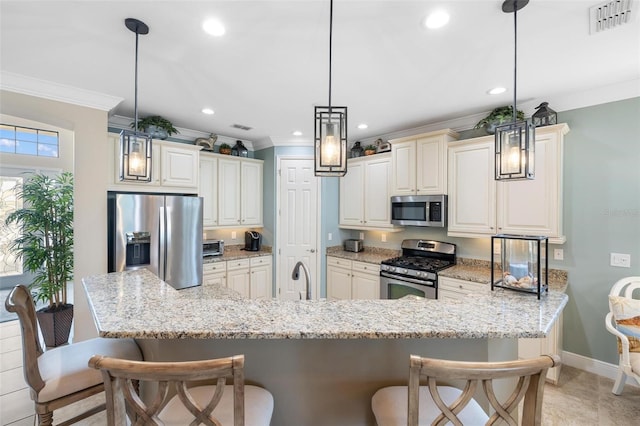 1254 Cielo Ct, North Venice, FL 34275 - kitchen with stainless steel appliances, a breakfast bar, visible vents, ornamental molding, and baseboards