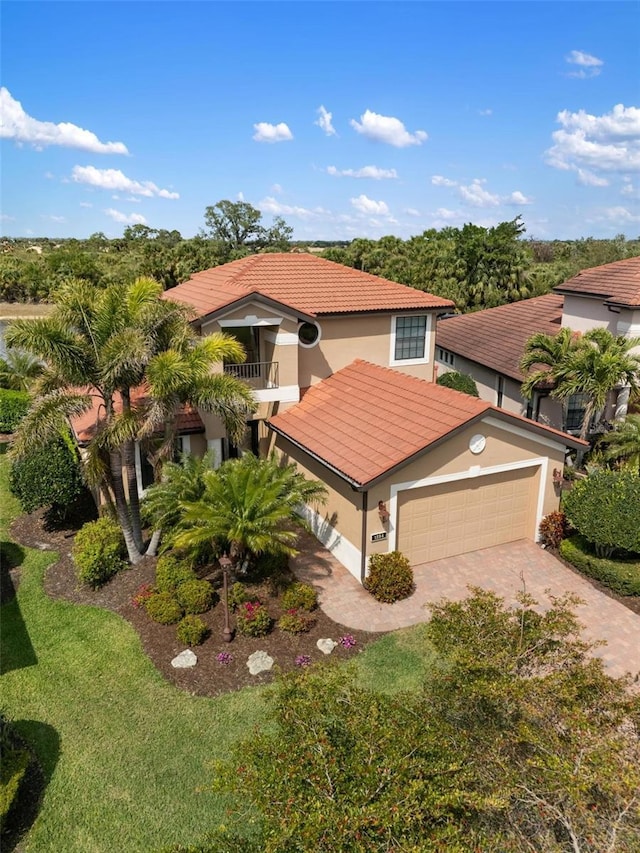 1254 Cielo Ct, North Venice, FL 34275 - mediterranean / spanish-style home with a tile roof, driveway, an attached garage, a balcony, and stucco siding