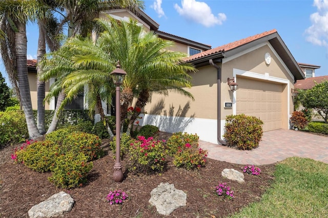 1254 Cielo Ct, North Venice, FL 34275 - mediterranean / spanish house with stucco siding, a tile roof, decorative driveway, and a garage