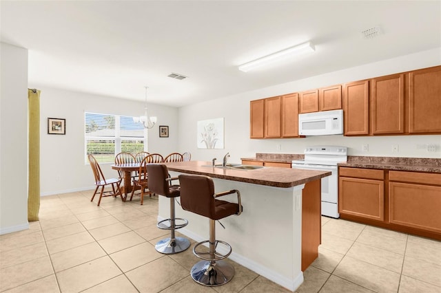 25525 Lambert Ln, Punta Gorda, FL 33950 - kitchen featuring visible vents, light tile patterned floors, a sink, white appliances, and a breakfast bar area