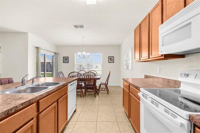 25525 Lambert Ln, Punta Gorda, FL 33950 - kitchen featuring a sink, white appliances, a chandelier, brown cabinetry, and light tile patterned flooring