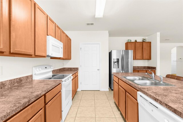 25525 Lambert Ln, Punta Gorda, FL 33950 - kitchen with light tile patterned floors, white appliances, arched walkways, visible vents, and a sink