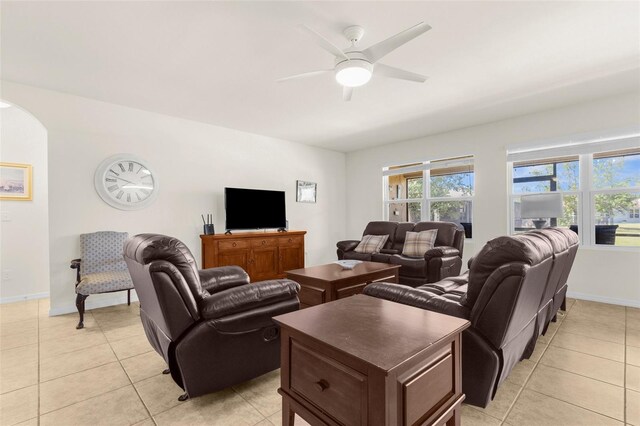 25525 Lambert Ln, Punta Gorda, FL 33950 - living room with arched walkways, baseboards, light tile patterned flooring, and ceiling fan