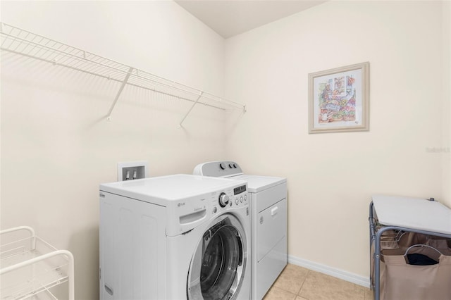 25525 Lambert Ln, Punta Gorda, FL 33950 - washroom with baseboards, light tile patterned floors, laundry area, and washing machine and clothes dryer