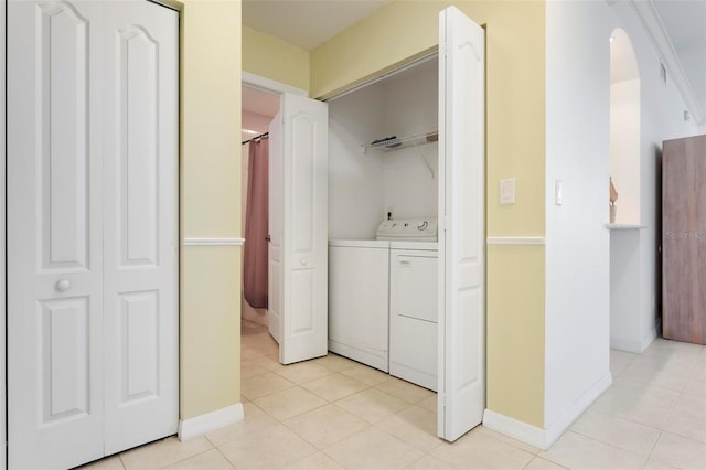 1007 Gondola Park Dr Unit 1007, Venice, FL 34292 - washroom featuring washing machine and dryer, light tile patterned floors, and arched walkways