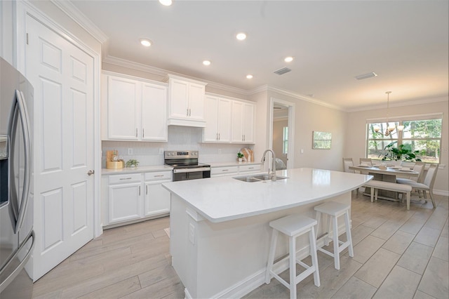 288 Soliera St, Nokomis, FL 34275 - kitchen featuring crown molding, wood finish floors, a center island with sink, a sink, and appliances with stainless steel finishes