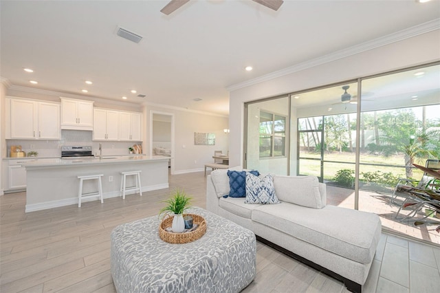 288 Soliera St, Nokomis, FL 34275 - living room featuring light wood-type flooring, visible vents, a healthy amount of sunlight, and a ceiling fan