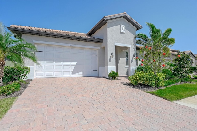 288 Soliera St, Nokomis, FL 34275 - view of front of house with decorative driveway, a tile roof, stucco siding, and a garage