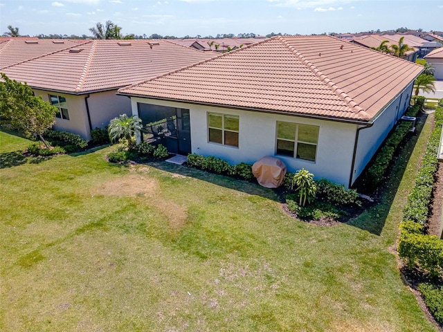 288 Soliera St, Nokomis, FL 34275 - rear view of house featuring stucco siding, a tile roof, and a yard