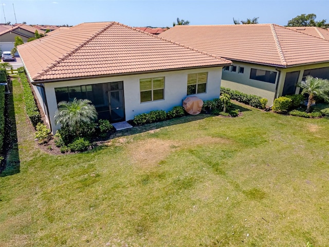 288 Soliera St, Nokomis, FL 34275 - back of house featuring stucco siding, a tiled roof, and a yard