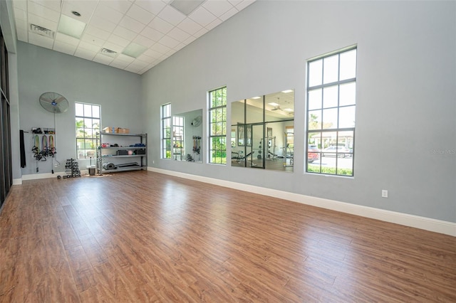 288 Soliera St, Nokomis, FL 34275 - interior space featuring visible vents, baseboards, wood finished floors, a high ceiling, and a paneled ceiling