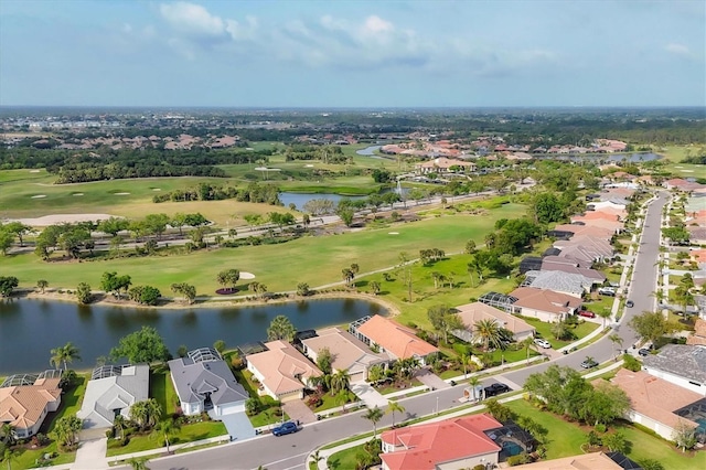 drone / aerial view with view of golf course, a residential view, and a water view