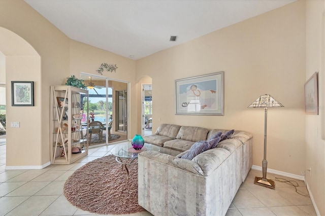 living room featuring baseboards, visible vents, arched walkways, and light tile patterned floors
