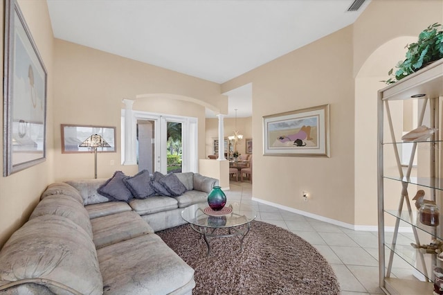 living room with light tile patterned floors, baseboards, visible vents, arched walkways, and an inviting chandelier