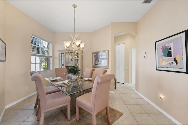 dining area with an inviting chandelier, light tile patterned floors, arched walkways, and baseboards