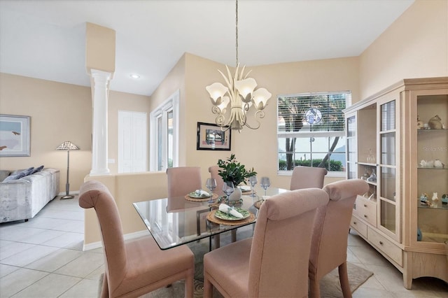 dining area featuring light tile patterned floors, a notable chandelier, baseboards, and ornate columns